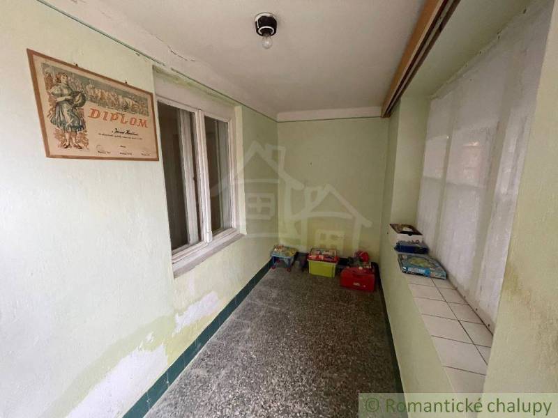 A hallway in a family house with old diplomas and storage boxes on the floor.