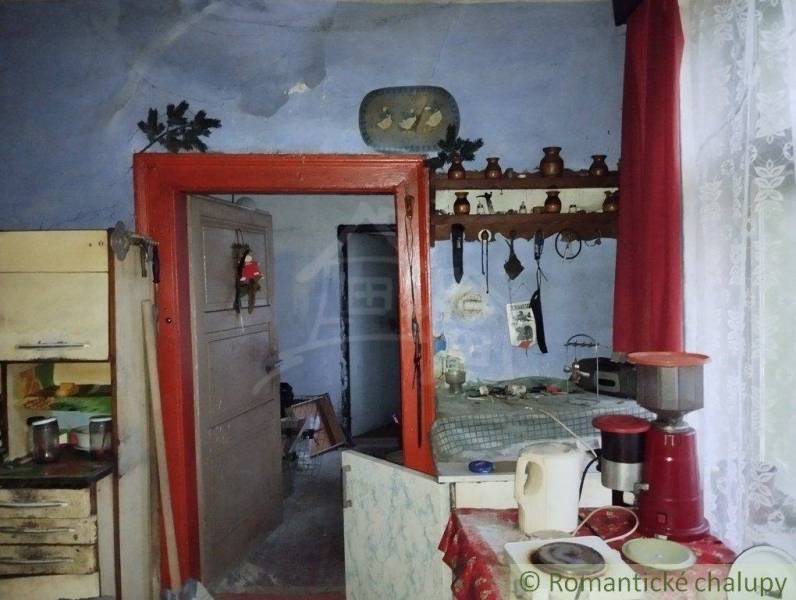 An older rural interior with kitchenware, a spice rack, and curtains in a family house.