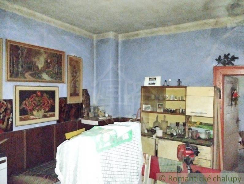 A room with paintings, furniture, and a family home atmosphere of a village interior full of memories.