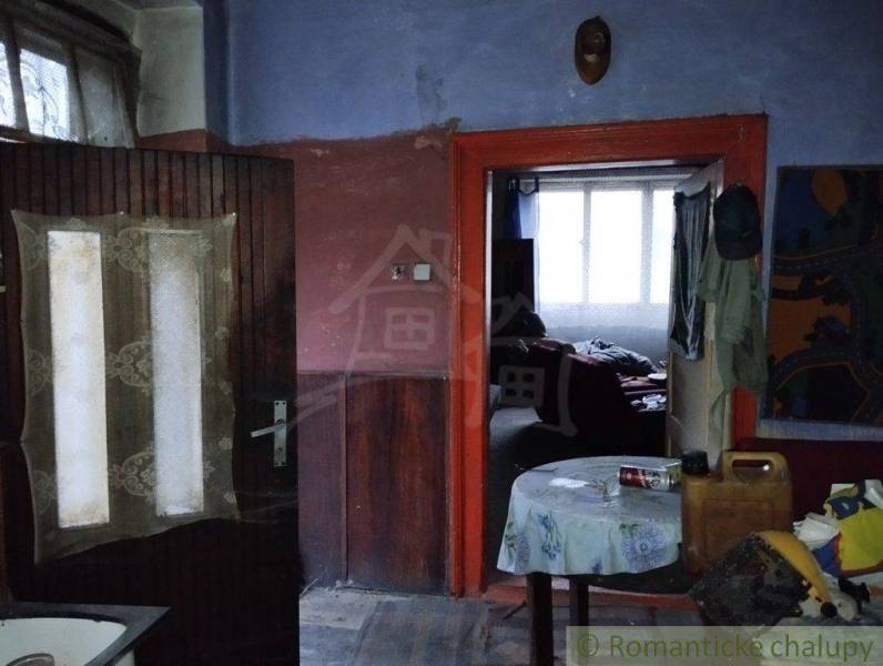 The interior of a dark room with a door and a table in a family house.