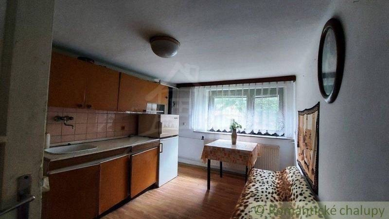 A simple kitchen in a family house with a window, table, and sofa.