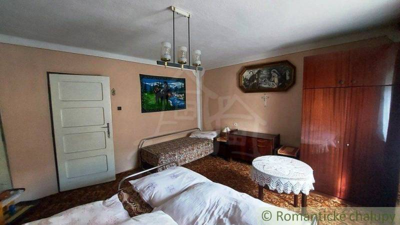 Traditional room interior with a bed in a family house, wooden furniture, paintings on the walls.