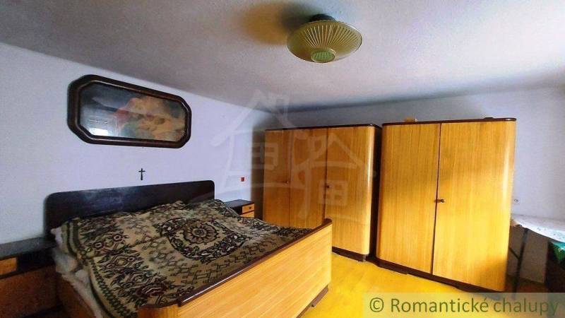 A bedroom in a family house with wardrobes and a bed, traditional country style.