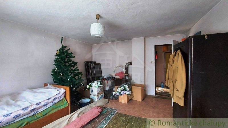 A room with a bed, family house, Christmas tree, boxes, furniture. Cottage atmosphere.