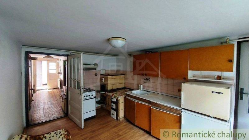 A kitchen in an older family house with classic cabinets and basic equipment.