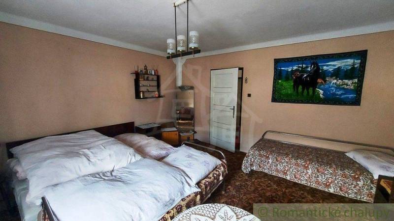 A bedroom in a family house with a painting of horses, one double bed, and one single bed.