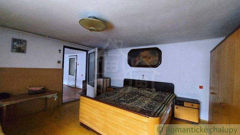 A bedroom in a family house with a bed, antique wardrobes, and a picture on the wall.