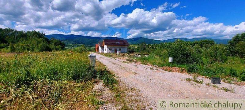 A country house surrounded by greenery with a view of the mountains, ideal for recreational plots.