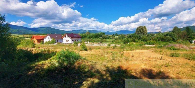 A meadow, houses, hills, clouds, and recreational properties in a picturesque natural setting.