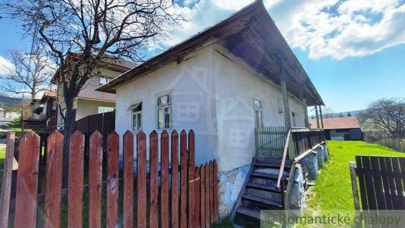 An old house surrounded by a wooden fence and lawn, ideal for unique properties.