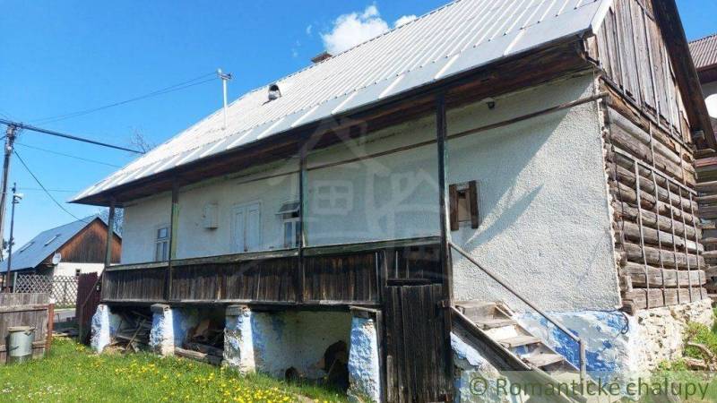 A historical cottage with a wooden structure, roof, stairs, unique rural properties.