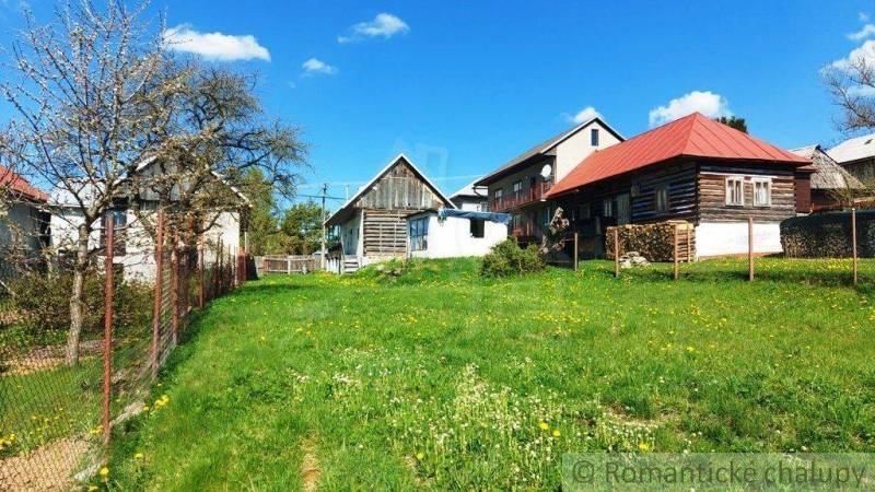 A country cottage with a lawn and a fence, offering a unique property with a peaceful atmosphere.