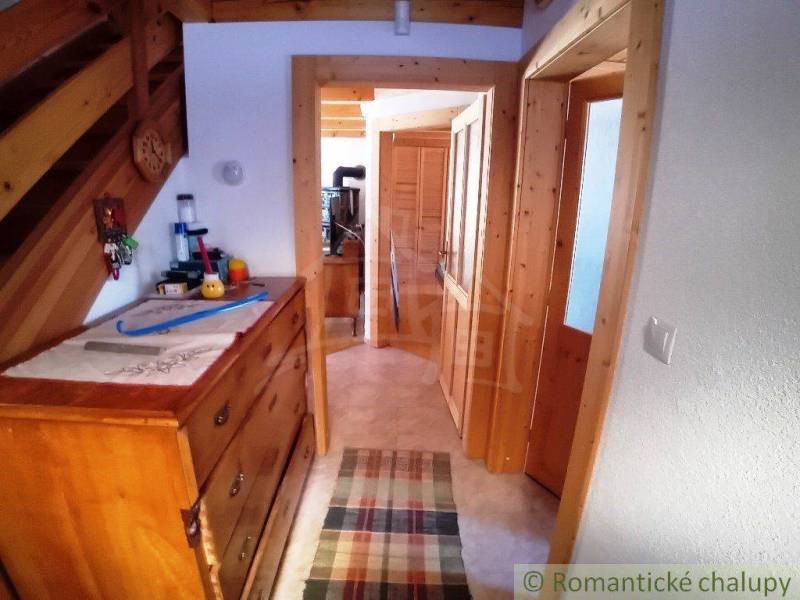An interior with stairs, a wooden dresser, and natural details in a cozy cabin.