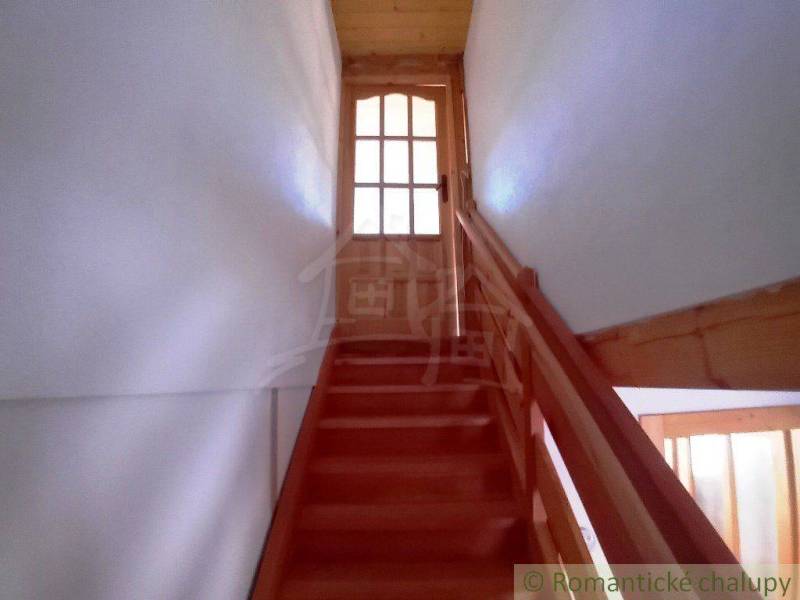 Wooden stairs in the cabin lead to glass doors, creating a cozy atmosphere.