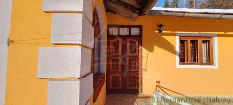 A house with wooden doors and windows, highlighted by colorful plaster, Unique properties.