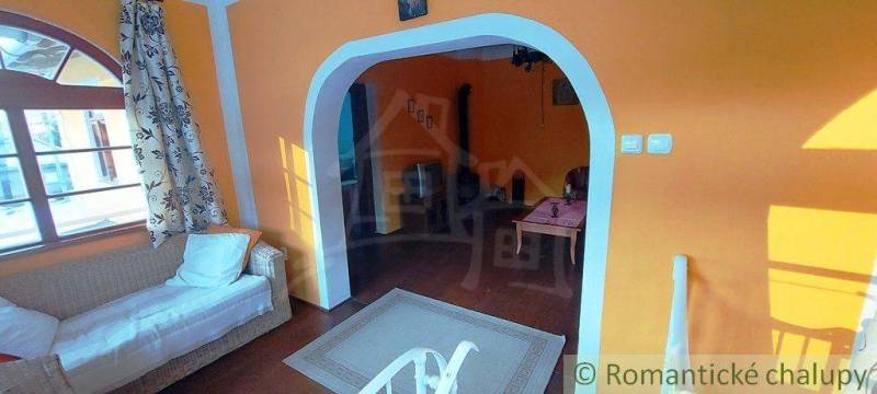Interior with an arched passage, orange walls, and a couch. A key to a unique property.