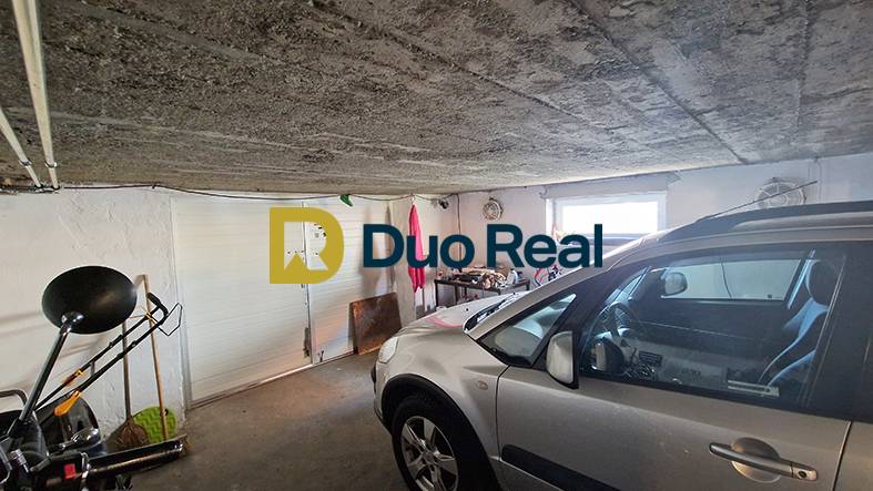 A garage in a family house with a car and tools.