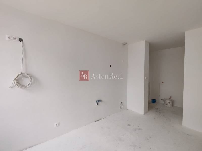 An empty room in a 3-room apartment, white walls and floor, preparation for installations.