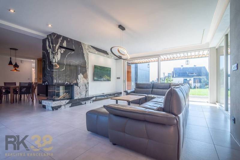 Living room of a family house with a sofa set, fireplace, and dining area.
