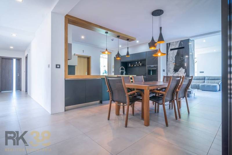 A dining room in a family house with stylish wooden furniture and lighting.