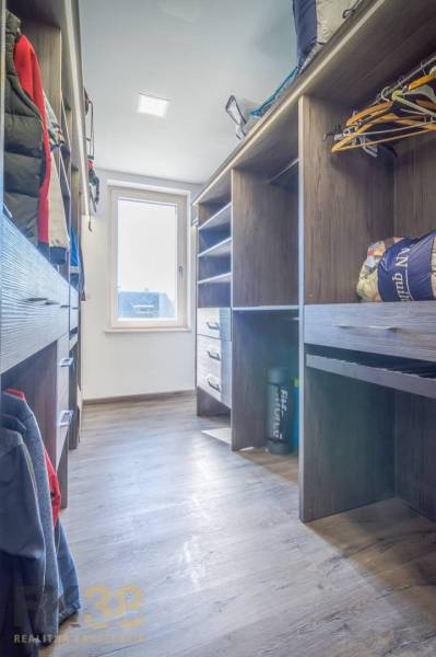 A wardrobe with wooden shelves and hangers in a family house.