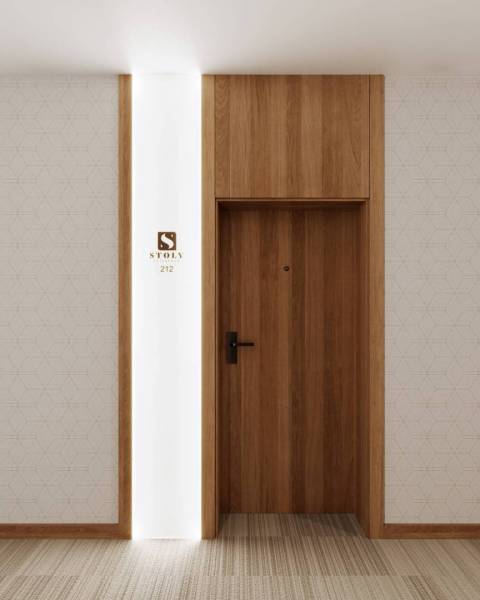 Bright interior of a holiday apartment with wooden doors and geometric wallpaper.