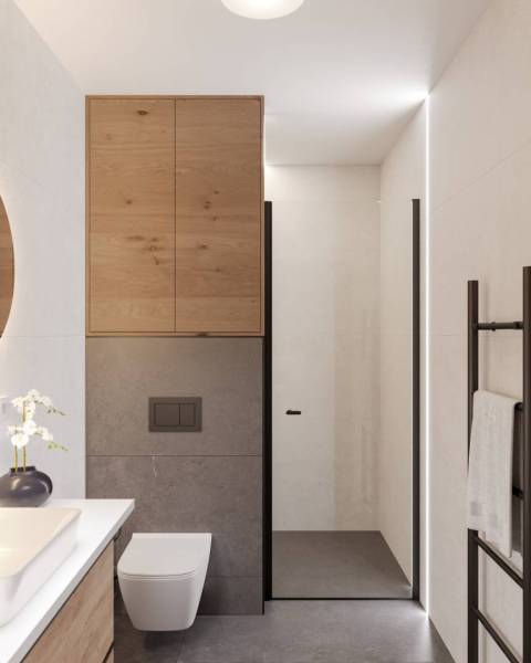 Bathroom in a holiday apartment with wooden cabinets, shower, and toilet.