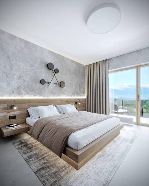 Elegant bedroom in a holiday apartment with a wooden bed and mountain view.
