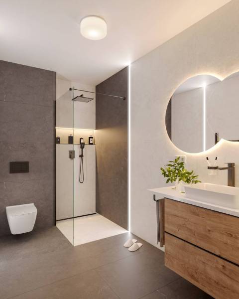 Bathroom in a holiday apartment with a shower, sink, and wooden cabinet.