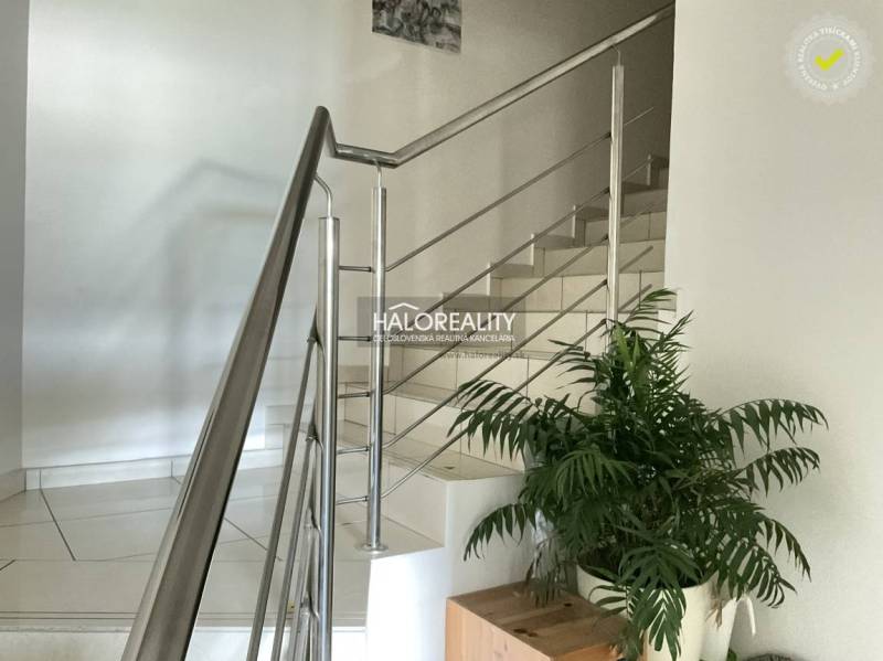 Interior of a 3-room apartment with white stairs and stainless steel railing.