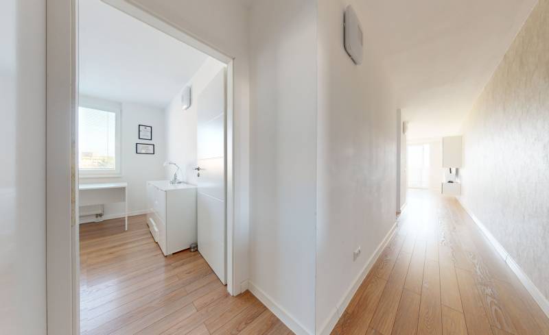 Hallway and office in a 3-room apartment with wooden flooring and white walls.
