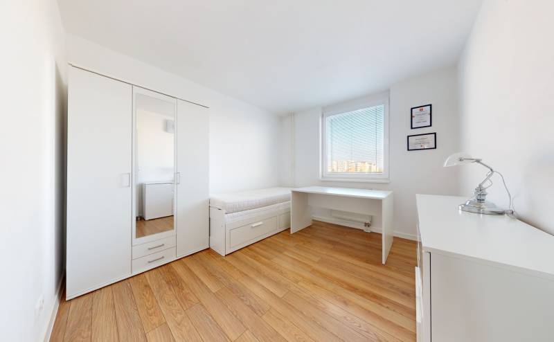A bright room with a bed, wardrobe, desk, and lamp in a 3-room apartment.
