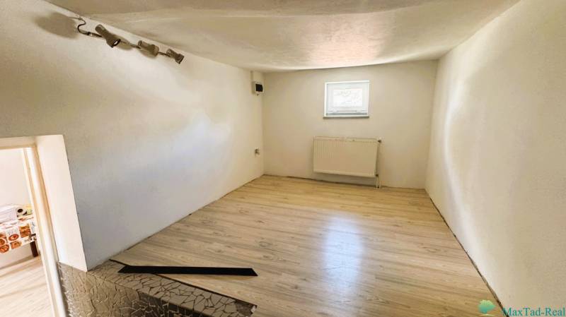 A room in a family house with laminate flooring and white walls.
