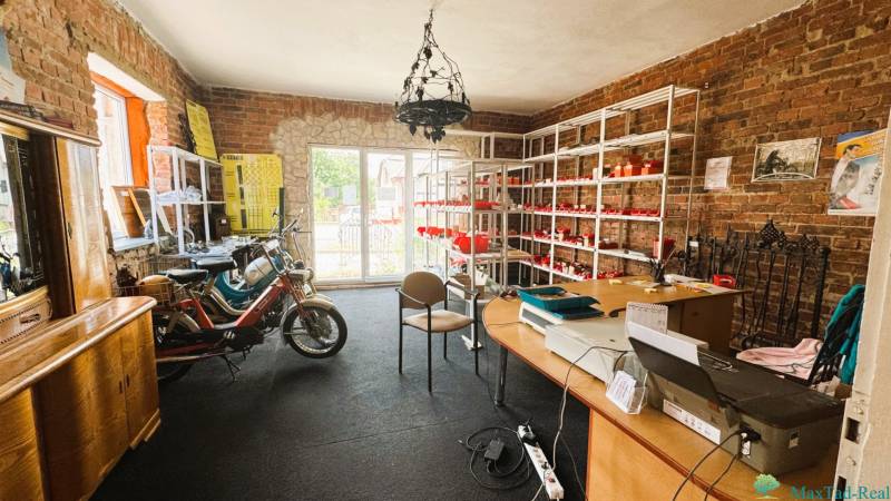 Interior of a family house with brick walls, a motorcycle, and shelves with goods.