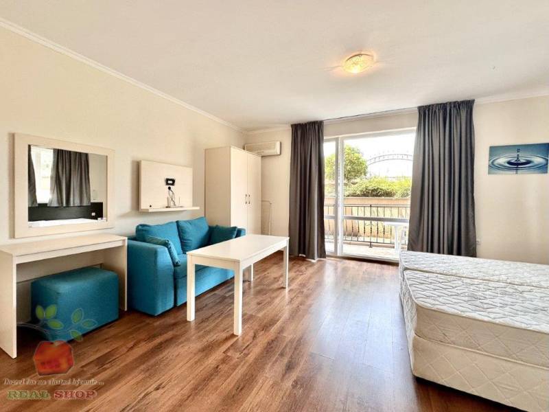 Recreational apartment with wooden floor, sofa, bed, balcony, and wardrobe.