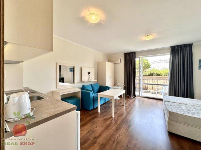 Interior of a holiday apartment with a kitchenette, living room, and access to a terrace.