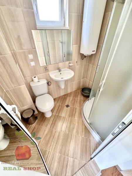 Bathroom in a holiday apartment with a toilet, shower, and sink.