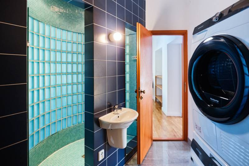 Bathroom with a sink, washing machine, and shower in a 4-room apartment.