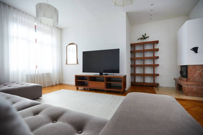 Living room in a 4-room apartment with a TV, sofa, and fireplace.