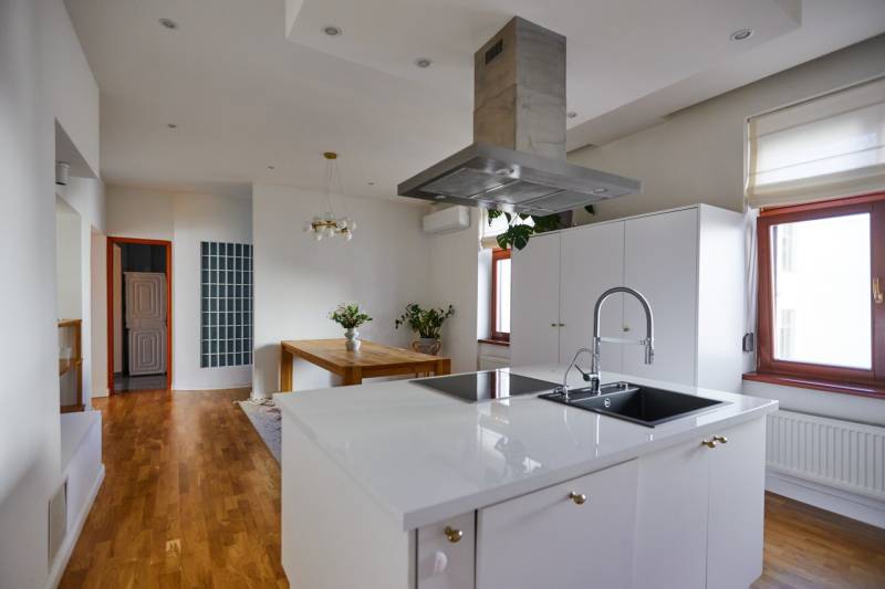 A kitchen with a stylish island and a dining table in a 4-room apartment.