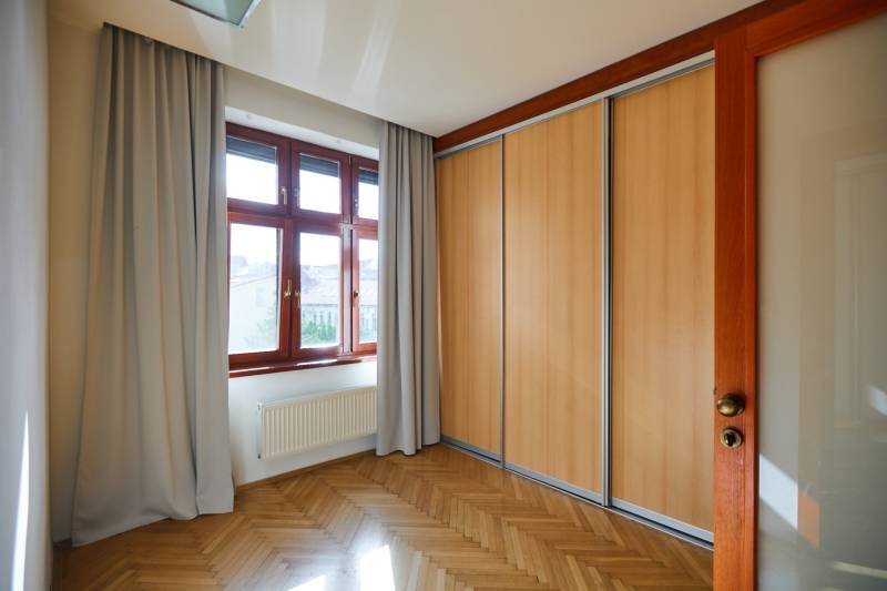 A room with a built-in wardrobe, wooden floors, and a large window in a 4-room apartment.