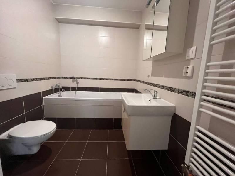 Bathroom with a bathtub, sink, and toilet in a 3-room apartment.