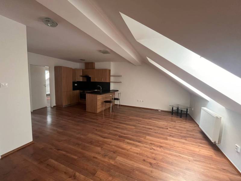 Attic kitchen and living room with wooden flooring in a 3-room apartment.