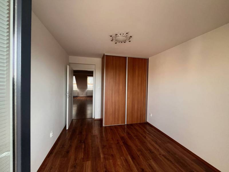 A room with a wooden floor and a built-in wardrobe in a 3-room apartment.
