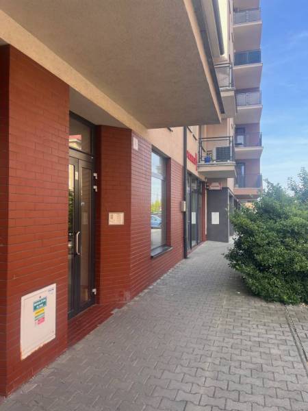 The exterior of a building in Dunajská Streda with a red brick facade and entrance doors.
