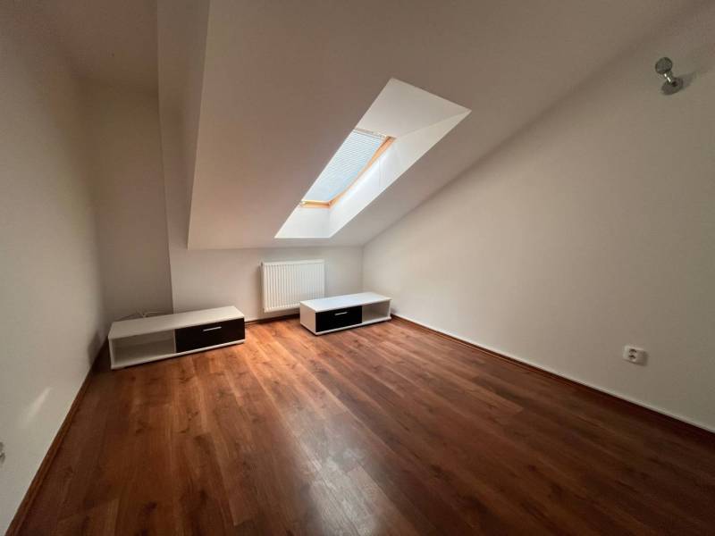 Attic room with wooden floor and skylight in a 3-room apartment.