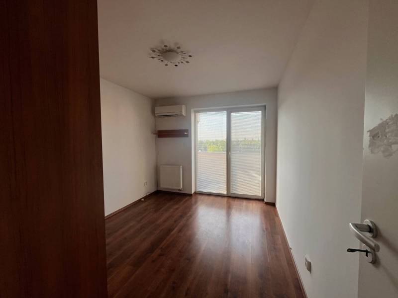 A room with a wooden floor and built-in air conditioning in a 3-room apartment.