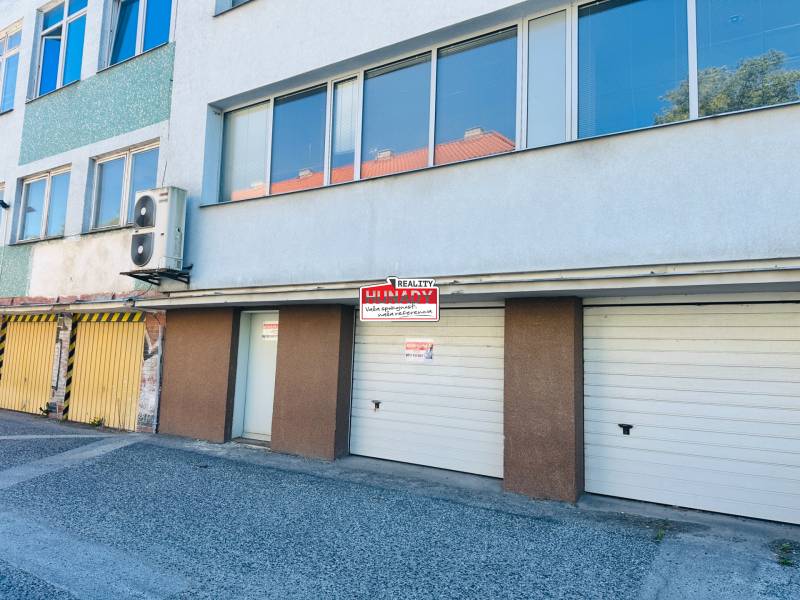 Garages on Štefánik Square in Spišská Nová Ves with entrances and an advertising board.