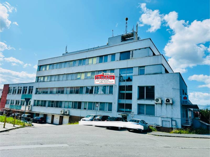 A multi-story building and cars on Štefánik Square, Spišská Nová Ves, garages.