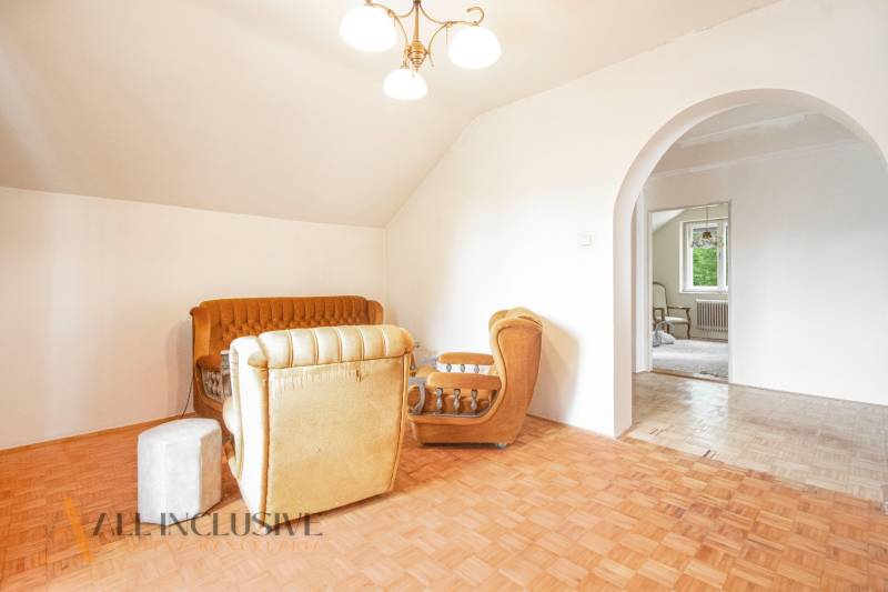 A comfortable living room in a family house with a retro sofa set and wooden flooring.